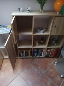 a wooden book shelf with books on it at Haus Lebensart Bansin in Neu Sallenthin