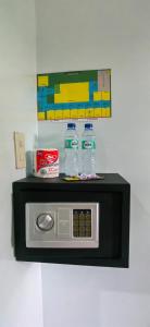 a microwave with two water bottles on top of it at Hashtag Tourist Inn in San Vicente +29 photos