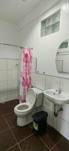 a bathroom with a toilet and a sink at Hashtag Tourist Inn in San Vicente