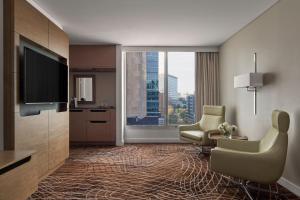 a hotel room with two chairs and a television at Melbourne Marriott Hotel in Melbourne