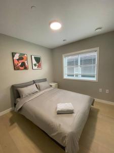 a bedroom with a large white bed with a window at New Modern Three-room Duplex-2793 in Vancouver