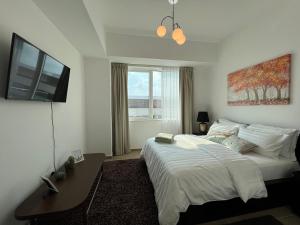 een slaapkamer met een bed, een tafel en een televisie bij Mayan La Vie Yas Island 905 MB4 in Abu Dhabi