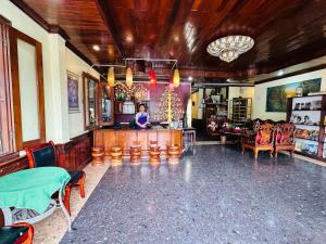 a woman standing at a bar in a restaurant at Visoun Luang Prabang Hotel in Luang Prabang