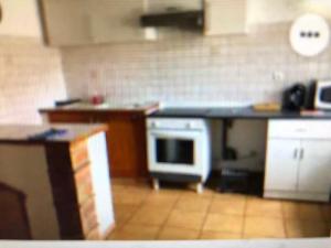 a kitchen with a counter and a stove top oven at F3 HOCHE 2 éme étage in Coursan