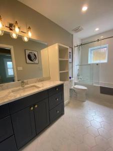 een badkamer met een wastafel, een toilet en een spiegel bij New Modern Theee-room Duplex-2791 in Vancouver