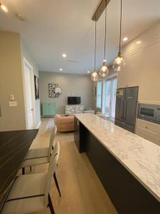 a kitchen with a long counter and a living room at New Modern Theee-room Duplex-2791 in Vancouver