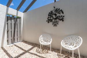 twee stoelen op een balkon met een plant aan de muur bij Beautiful Private Pool Home In-between Fort Myers Beach and Sanibel Island home in Fort Myers