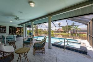 een patio met een zwembad en stoelen en een tafel bij Beautiful Private Pool Home In-between Fort Myers Beach and Sanibel Island home in Fort Myers