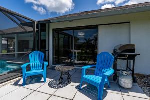 twee blauwe stoelen en een tafel op een patio bij Beautiful Private Pool Home In-between Fort Myers Beach and Sanibel Island home in Fort Myers