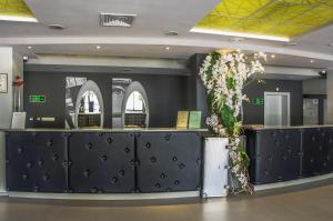 a lobby with a counter with flowers on it at Hotel Gladiola Star in Golden Sands