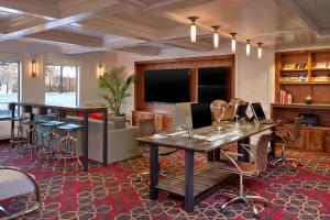 Habitación con mesas, sillas y TV. en Four Points by Sheraton Mall of America Minneapolis Airport, en Richfield
