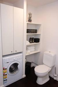 a bathroom with a toilet and a washing machine at #55highstreetauckland in Auckland