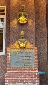 a sign in front of a building with two statues at OKAY Boutique Siem Reap in Phumi Ta Phul