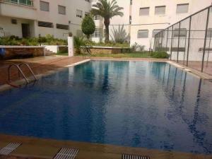 una gran piscina de agua azul frente a un edificio en Appartement de standing calme en centre ville IMAZUR en Tánger