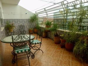 a patio with a table and chairs and potted plants at Appartement de standing calme en centre ville IMAZUR in Tangier