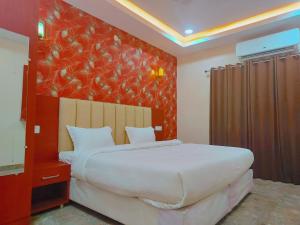 a bedroom with a large bed and a red wall at Awadh Samrat Resort in Ayodhya