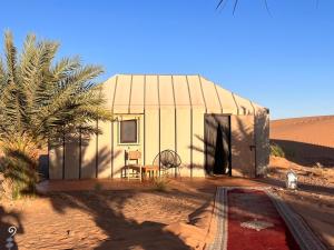 a small building in the middle of the desert at Erg Chebbi Sahara Camp in Merzouga