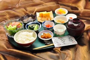 Satsuma Resort Hotel في Satsuma: صينية طعام مع أطباق على طاولة