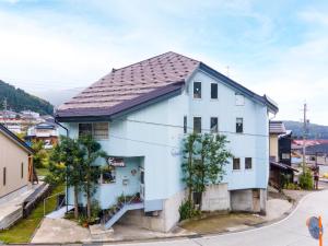 a white house with a black roof at Fujiyoshi in Nozawa Onsen