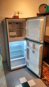 un réfrigérateur vide avec sa porte ouverte dans une cuisine dans l'établissement The EH's Homestay Marina View Villa PortDickson, à Port Dickson