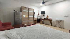 1 dormitorio con cama, nevera y escritorio en Raniah homestay en Kuching