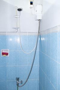 y baño con ducha y azulejos azules. en D Guest House Ilocos en Laoag