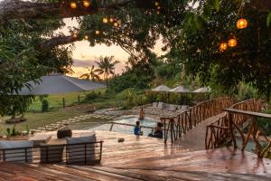 un bambino è seduto su una terrazza di legno di The Hillside Resort Siargao a General Luna