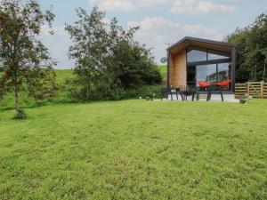 a small cabin in a field with a grass yard at Little Shelve Barn in Shrewsbury