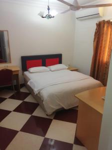 a bedroom with a bed and a checkered floor at Sun City Hotel in Muscat