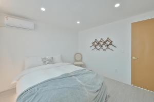 a white bedroom with a bed and a wall at 3room+2bath hongdae 165sqm in Seoul