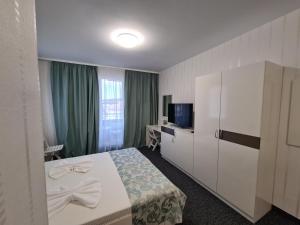 a hotel room with a bed and a television at Villa Yanevi in Ravda +25 photos