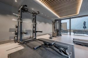 a room with a gym with a bench and tread machines at Hotel Alpina Sölden - Adults Only in Sölden
