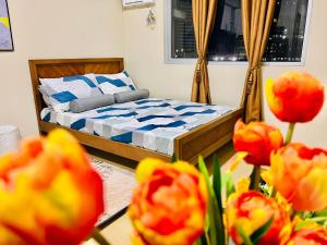 1 dormitorio con 1 cama y flores rojas en * * *N Affordable Urban Luxury, en Iloilo City
