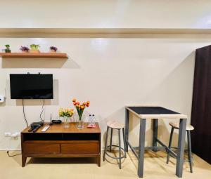 sala de estar con TV, mesa y taburete en * * *N Affordable Urban Luxury, en Iloilo City
