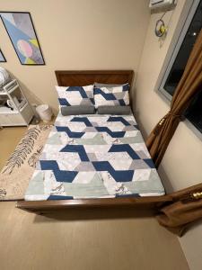 1 cama con edredón azul y blanco en un dormitorio en * * *N Affordable Urban Luxury, en Iloilo City