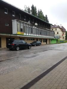 two cars parked in front of a building at Hotel Nico in Špindlerův Mlýn