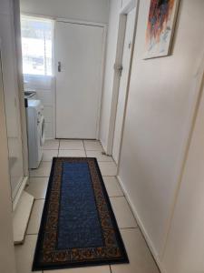 a bathroom with a rug on the floor next to a door at Blue House on Murray River in Cobram