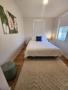 a bedroom with a large bed and a large window at Blue House on Murray River in Cobram