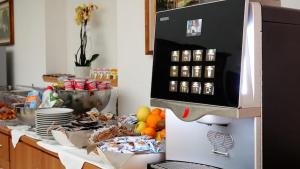 a kitchen with a counter with a microwave and fruit at Hotel Le Palme in Varazze