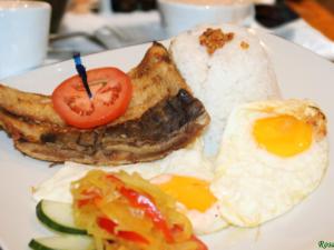un piatto di prodotti per la colazione con uova e pane tostato di Rosas Garden Hotel a Manila