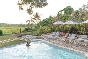 una pareja en la piscina de un complejo en The Hillside Resort Siargao en General Luna