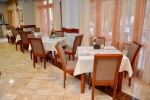 a dining room with tables and chairs and windows at Hotel Stella di Mare in Budva