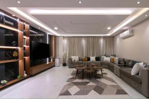 كمباوند تليد - حطين - الملقا - بوليفارد في الرياض: غرفة معيشة مع أريكة وتلفزيون