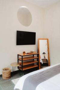 a bedroom with a tv and a bed and a mirror at The Volter Yogyakarta in Ngingas