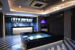 a room with a hot tub and a tv in it at ホテルウォーターゲート富山 大人用 in Toyama
