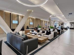 a lobby with couches and tables in a building at 1 Bedroom Luxury Apartment in Luxury Hotel & Apartments in Sandton Central in Johannesburg