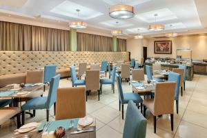 un comedor con mesas y sillas azules en Protea Hotel by Marriott Lusaka, en Lusaka