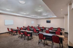 a conference room with tables and chairs and a screen at Protea Hotel by Marriott Lusaka in Lusaka