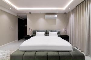 ein Schlafzimmer mit einem großen weißen Bett in einem Zimmer in der Unterkunft كمباوند تليد - حطين - الملقا - بوليفارد in Riad