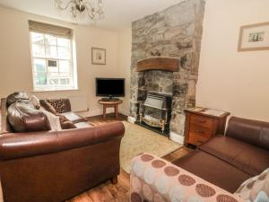 sala de estar con sofá y chimenea en Ty Potiwr, en Conwy